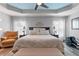 Spacious main bedroom with a sitting chair, ceiling fan, and neutral color decor at 6328 Merhottein Loop, The Villages, FL 32163