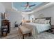Stylish main bedroom showcasing a tray ceiling, wooden floors and a light color palette at 6328 Merhottein Loop, The Villages, FL 32163