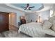Main bedroom featuring a tray ceiling, and TV cabinet, and light-colored floors at 6328 Merhottein Loop, The Villages, FL 32163
