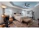 Spacious main bedroom with a ceiling fan, sitting area, and stylish decor at 6328 Merhottein Loop, The Villages, FL 32163