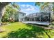 Expansive backyard featuring a screened pool, patio area, and lush green lawn, ideal for outdoor activities at 687 Saranac Dr, Winter Springs, FL 32708