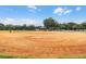 A well-maintained baseball field with dirt infield, lush green outfield and shaded spectator seating area at 687 Saranac Dr, Winter Springs, FL 32708