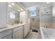 Bright bathroom featuring dual sinks, soaking tub and walk in shower at 687 Saranac Dr, Winter Springs, FL 32708