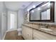 Bathroom vanity with double sinks and framed mirror, complemented by decorative lighting and a door to the outside at 687 Saranac Dr, Winter Springs, FL 32708
