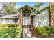 Inviting home entrance with brick accents, manicured landscaping, and a stylish front door with a transom window at 687 Saranac Dr, Winter Springs, FL 32708
