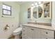 Bathroom with white wainscoting, updated vanity, and decorative mirror at 745 Oak Ln, Orange City, FL 32763