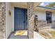 Charming front entrance with a blue door, brick accents, and a welcoming sunflower mat at 745 Oak Ln, Orange City, FL 32763