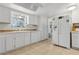 Bright kitchen with white appliances and cabinets, tile backsplash, and plenty of counter space at 745 Oak Ln, Orange City, FL 32763