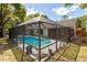 Aerial view of a sparkling pool surrounded by a screened enclosure and lush landscaping at 745 Oak Ln, Orange City, FL 32763