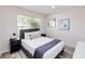 Comfortable bedroom with a large window, modern decor, and cozy bedding at 7803 Laurel Oak Ln, Kissimmee, FL 34747
