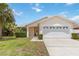 Charming single-story home featuring a two-car garage, well-maintained lawn, and mature landscaping at 7803 Laurel Oak Ln, Kissimmee, FL 34747