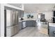 Spacious kitchen with stainless steel appliances, gray cabinetry, and an open view to the dining area at 7803 Laurel Oak Ln, Kissimmee, FL 34747