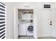 Convenient laundry room with washer, dryer, and overhead storage, next to the game zone at 7803 Laurel Oak Ln, Kissimmee, FL 34747