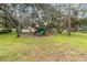 Community playground featuring a slide and play equipment surrounded by mature trees offering ample shade at 7803 Laurel Oak Ln, Kissimmee, FL 34747