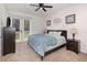 This bedroom features light pink walls, a ceiling fan, carpet flooring, and a sliding glass door to the outside at 8001 Cool Breeze Dr # 118, Orlando, FL 32819