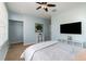 This bedroom features a ceiling fan, a TV, carpet flooring, light blue walls, and a large closet at 8001 Cool Breeze Dr # 118, Orlando, FL 32819