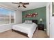 Bedroom featuring a ceiling fan, carpet flooring, dark green accent wall, and a window overlooking the outside at 8001 Cool Breeze Dr # 118, Orlando, FL 32819