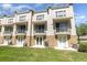 Townhome complex with a grassy front lawn and small balconies on each unit at 8001 Cool Breeze Dr # 118, Orlando, FL 32819