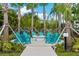 Community fire pit with Adirondack chairs, surrounded by lush landscaping and palm trees at 8001 Cool Breeze Dr # 118, Orlando, FL 32819