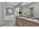 Bright bathroom features a double vanity, soaking tub, and neutral color palette at 8471 Secret Key Cv, Kissimmee, FL 34747