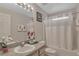 Bright bathroom featuring a vanity with sink, flowers and shower with white curtain at 8471 Secret Key Cv, Kissimmee, FL 34747