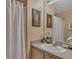 Bright bathroom featuring a vanity with sink, flowers and shower with white curtain at 8471 Secret Key Cv, Kissimmee, FL 34747