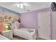 ' bedroom with a princess mural, twin beds with themed bedding, and soft purple walls at 8471 Secret Key Cv, Kissimmee, FL 34747