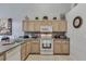 Well-lit kitchen featuring light wood cabinets, appliances, and tiled flooring for a clean, classic look at 8471 Secret Key Cv, Kissimmee, FL 34747