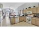 Bright kitchen with light wood cabinets, white appliances, and open layout to the living area at 8471 Secret Key Cv, Kissimmee, FL 34747
