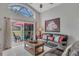 A cozy living room featuring a painting, tile floors, a large window, and sliding door to a screened-in pool area at 8471 Secret Key Cv, Kissimmee, FL 34747