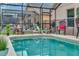 A lovely view of the screened-in pool and the surrounding lanai, with lounge seating for relaxing by the water at 8471 Secret Key Cv, Kissimmee, FL 34747