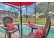The screened-in pool features chairs with cushions and an inflatable flamingo, with a grassy view beyond at 8471 Secret Key Cv, Kissimmee, FL 34747