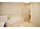 Bathroom featuring garden tub, glass shower, and neutral tile at 8761 The Esplanade # 6, Orlando, FL 32836