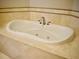 Large oval bathtub with whirlpool jets and tile surround at 8761 The Esplanade # 6, Orlando, FL 32836