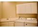 Convenient laundry room featuring modern washer and dryer units, plus built-in sink and cabinetry at 8761 The Esplanade # 6, Orlando, FL 32836