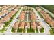 Aerial view of rows of townhomes featuring terracotta roofs and manicured lawns and landscaping at 9004 Majesty Palm Rd, Kissimmee, FL 34747