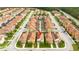 Bird's eye view of a neighborhood showcasing two-story homes, terracotta roofs, and lush landscaping at 9004 Majesty Palm Rd, Kissimmee, FL 34747
