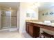 Well-lit bathroom with a glass-enclosed shower and vanity with granite countertops at 9004 Majesty Palm Rd, Kissimmee, FL 34747