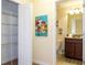 View of closet, colorful painting, and partial bathroom with vanity, sink and toilet at 9004 Majesty Palm Rd, Kissimmee, FL 34747