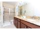 Elegant bathroom featuring double sinks, granite countertops, and a glass-enclosed shower at 9004 Majesty Palm Rd, Kissimmee, FL 34747