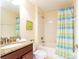 Bright bathroom features a granite vanity and shower-tub combination at 9004 Majesty Palm Rd, Kissimmee, FL 34747
