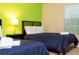 Bedroom featuring two twin beds and vibrant green wall at 9004 Majesty Palm Rd, Kissimmee, FL 34747