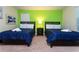 Bedroom showcasing two twin beds, nightstand, and green accent wall at 9004 Majesty Palm Rd, Kissimmee, FL 34747