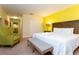 Cozy bedroom with a king bed, sitting chair, and walk in closet at 9004 Majesty Palm Rd, Kissimmee, FL 34747