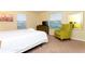 Bright bedroom with a comfortable bed, dresser, television, and a green accent chair at 9004 Majesty Palm Rd, Kissimmee, FL 34747