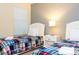Bright bedroom features two beds with plaid bedding and a white nightstand at 9004 Majesty Palm Rd, Kissimmee, FL 34747