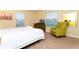 Bright bedroom with a comfortable bed, dresser, television, and a green accent chair at 9004 Majesty Palm Rd, Kissimmee, FL 34747