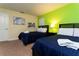 Bright bedroom features two beds with blue striped bedding and colorful wall art at 9004 Majesty Palm Rd, Kissimmee, FL 34747