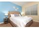 A brightly lit bedroom features a cozy king-sized bed with fresh white linens and stylish blue accent pillows at 9004 Majesty Palm Rd, Kissimmee, FL 34747