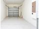 Spacious two car garage with white walls and ceiling, and a partially open door at 9004 Majesty Palm Rd, Kissimmee, FL 34747